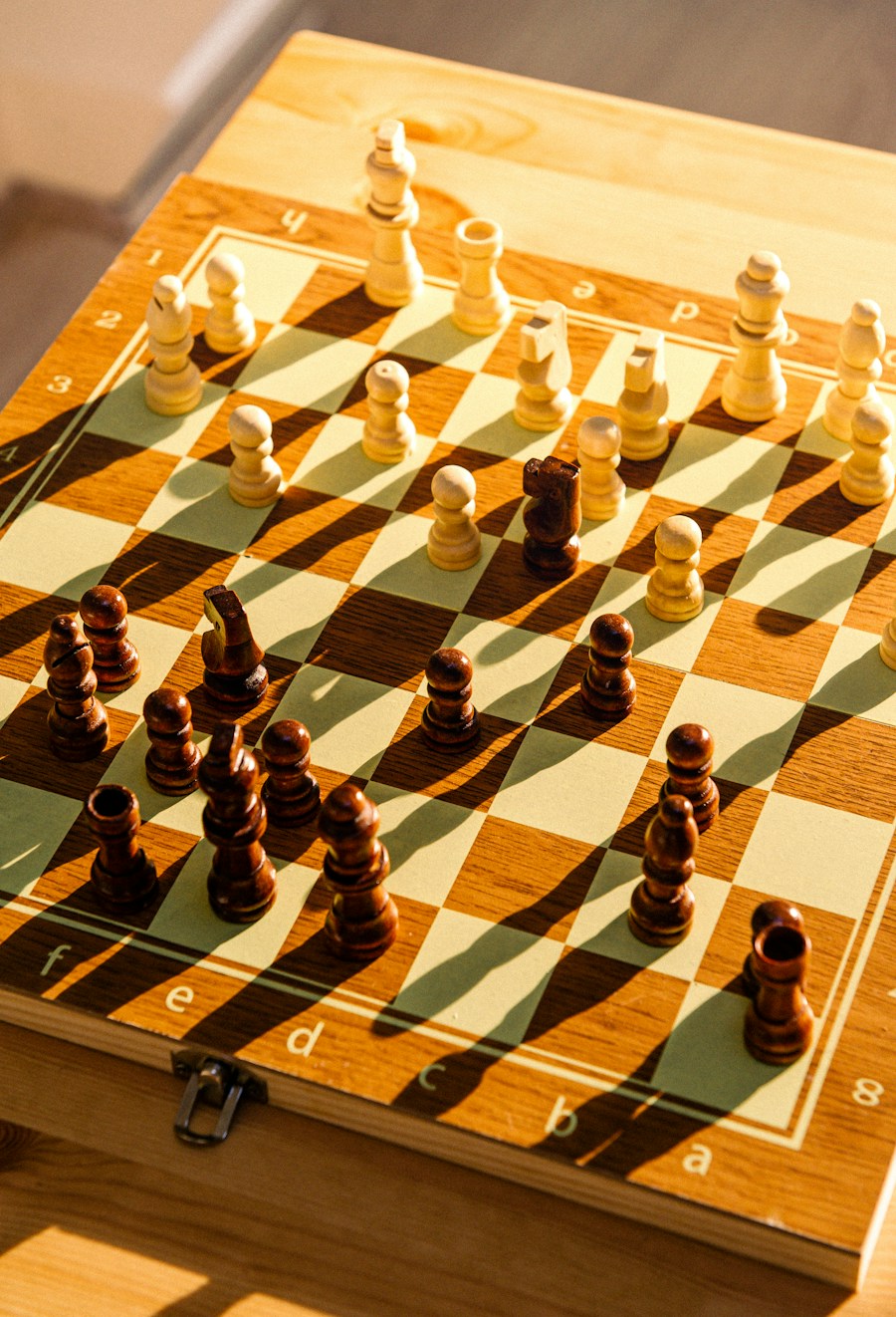 Wooden chess pieces arranged on a wooden chessboard