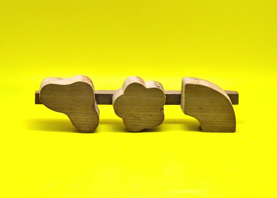 Three natural wooden shapes on a matching puzzle base