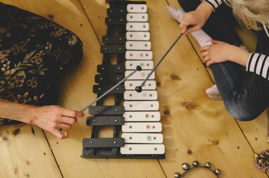 Children playing a tabletop set of metal musical bars with mallets